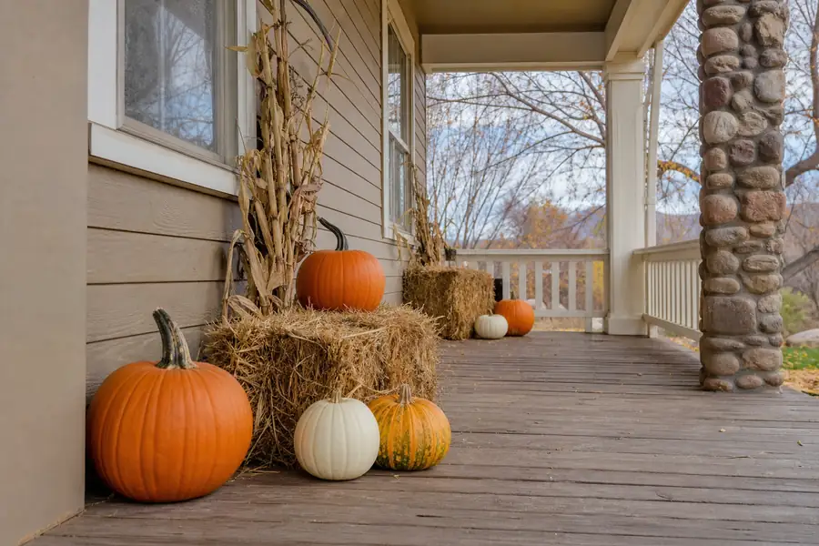 Colorado porch decorated with pumpkins and hay bales in warm afternoon autumn light